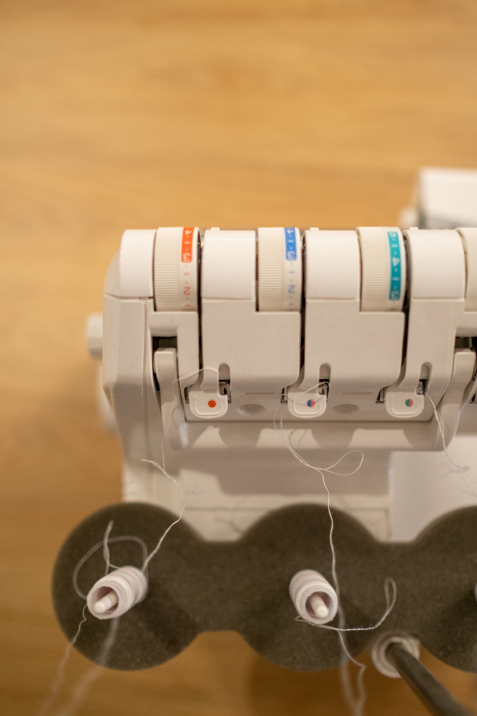 An overlock serger sewing machine loaded with multiple colored thread spools ready for stitching