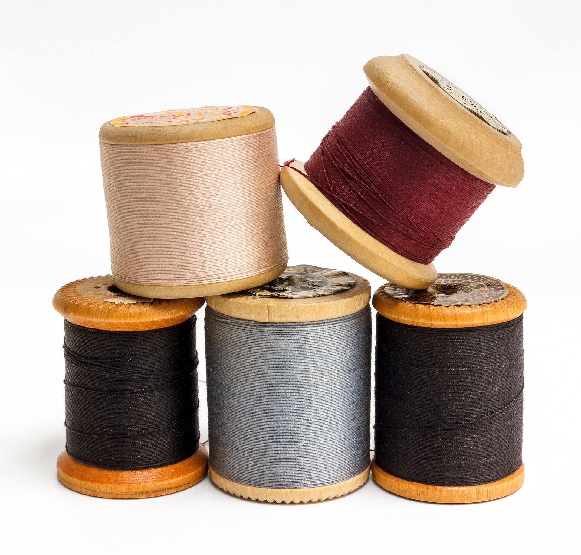 Colorful thread spools arranged in rows on a surface