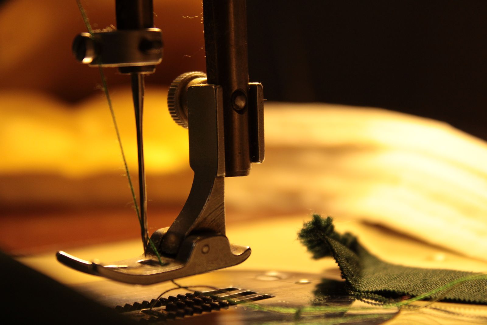 Close-up of a needle stitching fabric showing the thread path and needle detail