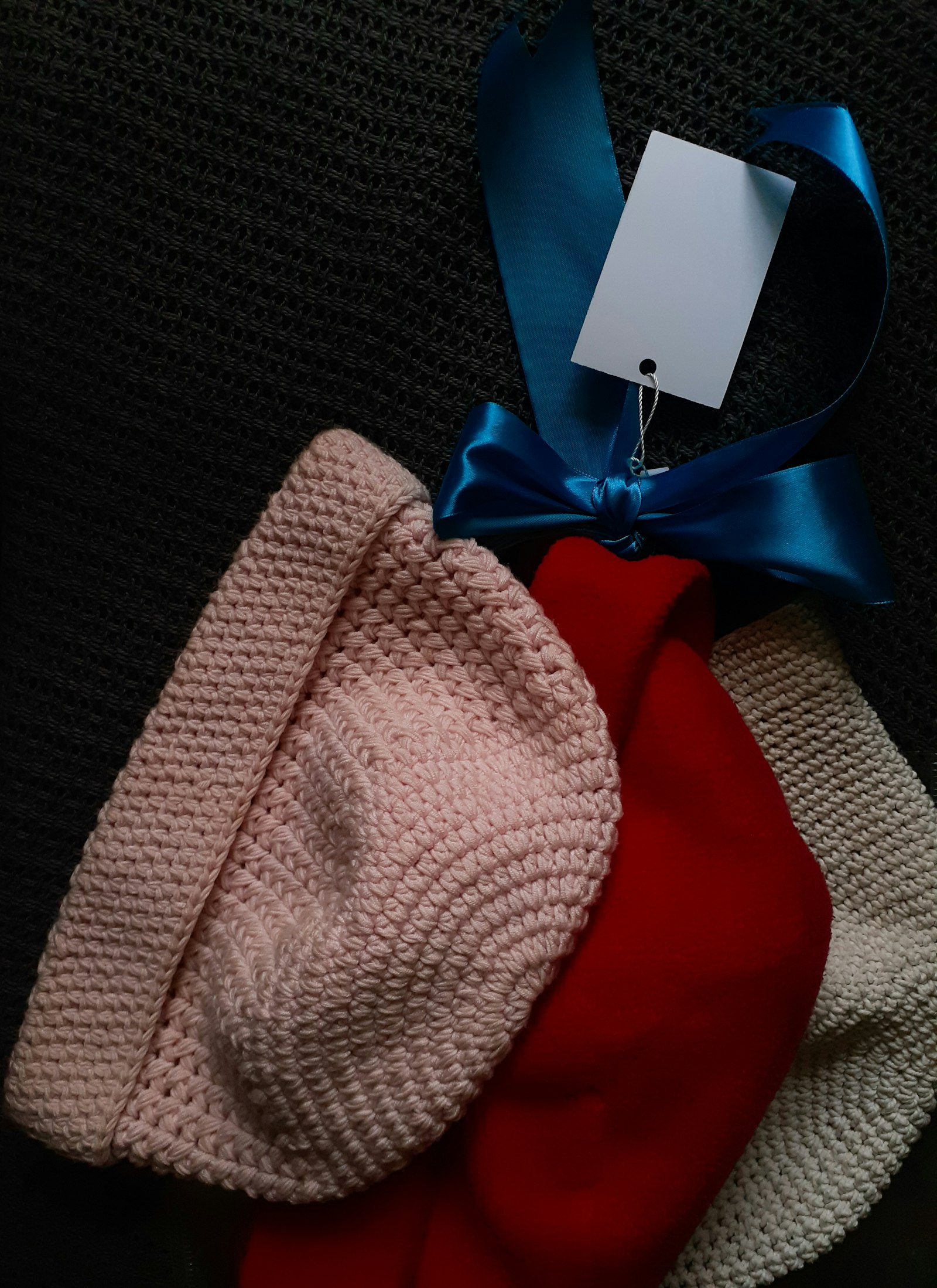 A stack of colorful knit winter beanies in various shades, shown folded