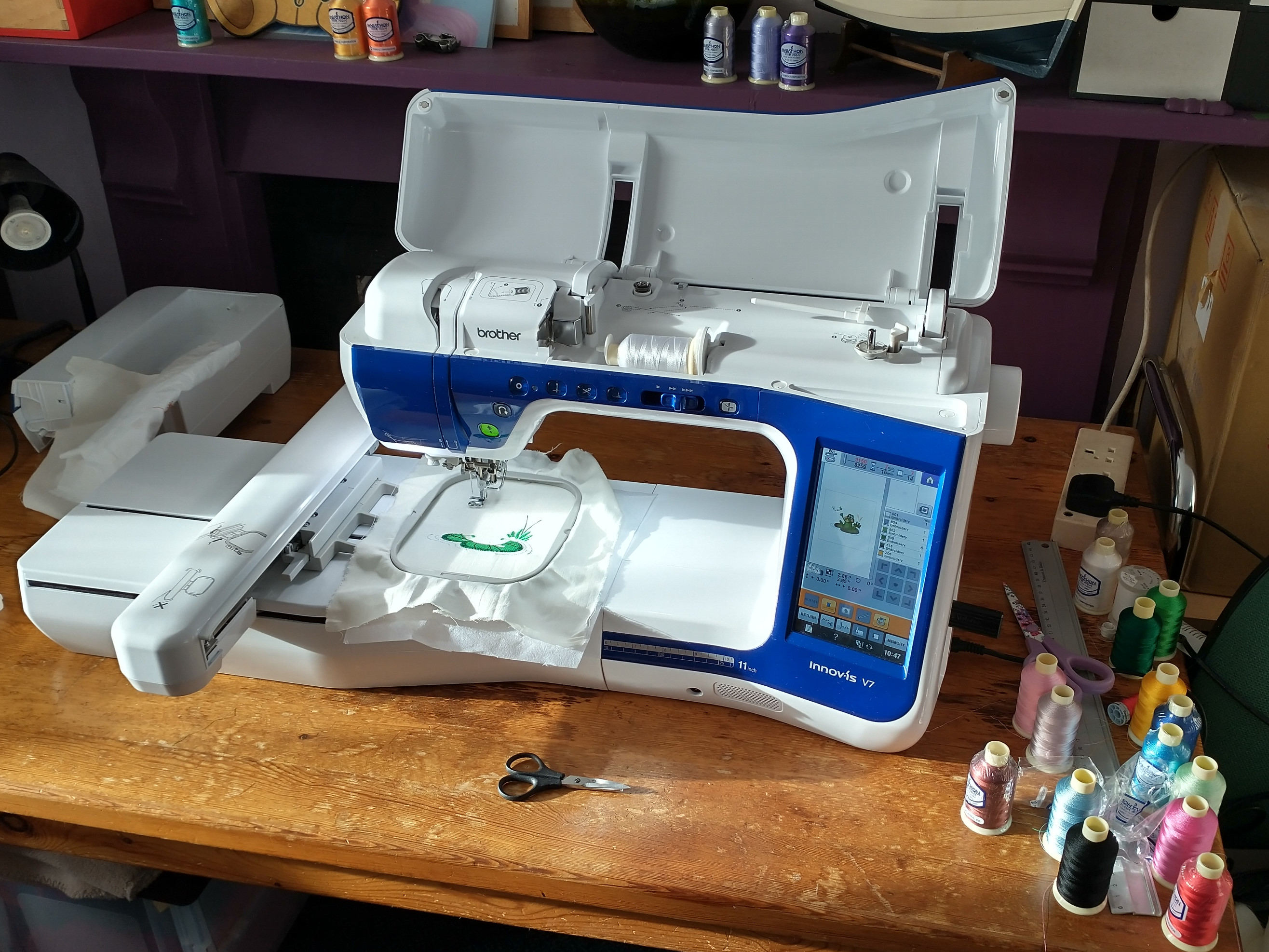 A Brother computerized embroidery machine actively stitching a design onto fabric held in a hoop