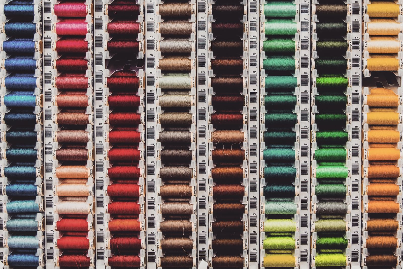 Rows of colorful thread spools stacked on a surface