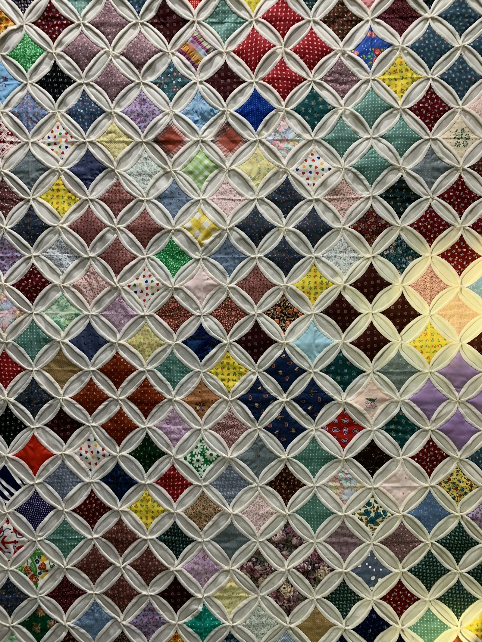 Close-up of a multicolored patchwork quilt showing dense geometric piecing