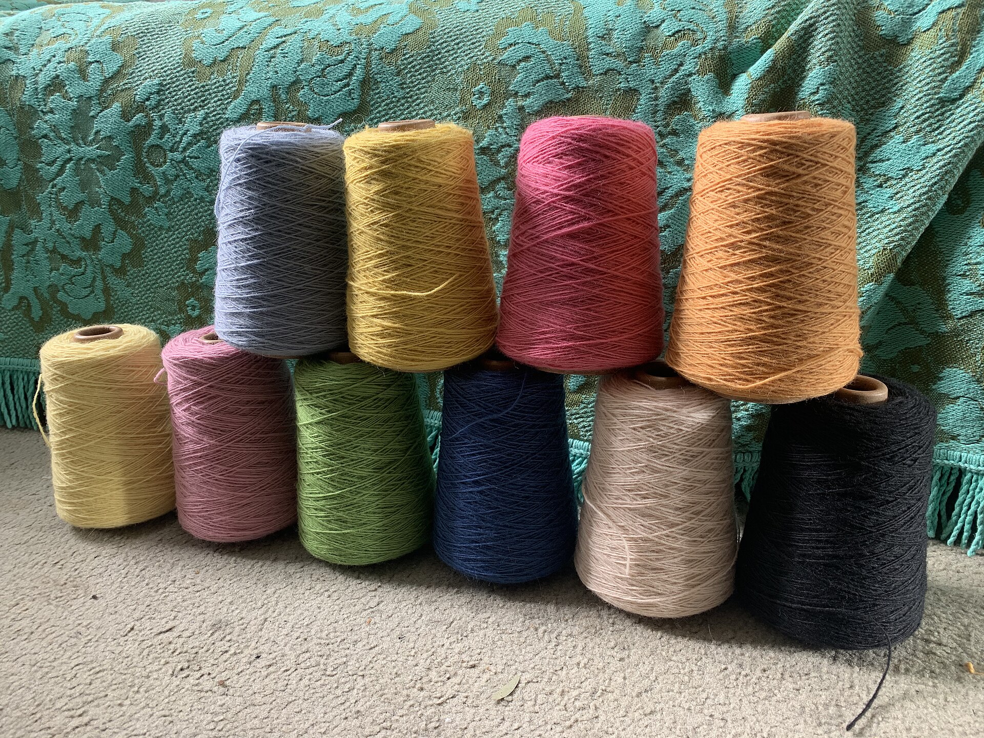 Cones of thread mounted on the spool stand of an overlocker